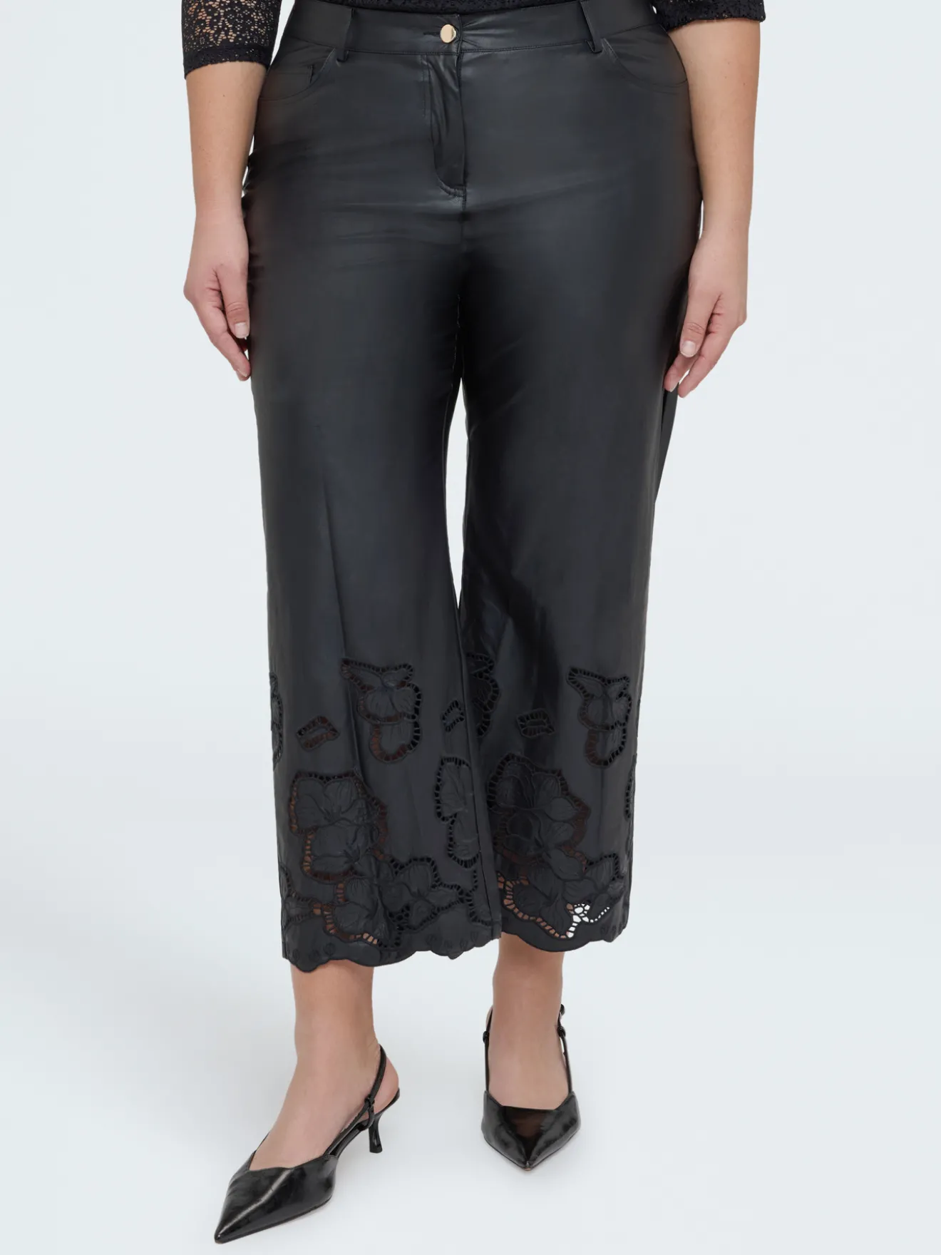 Pantaloni cropped in tessuto spalmato con motivi floreali